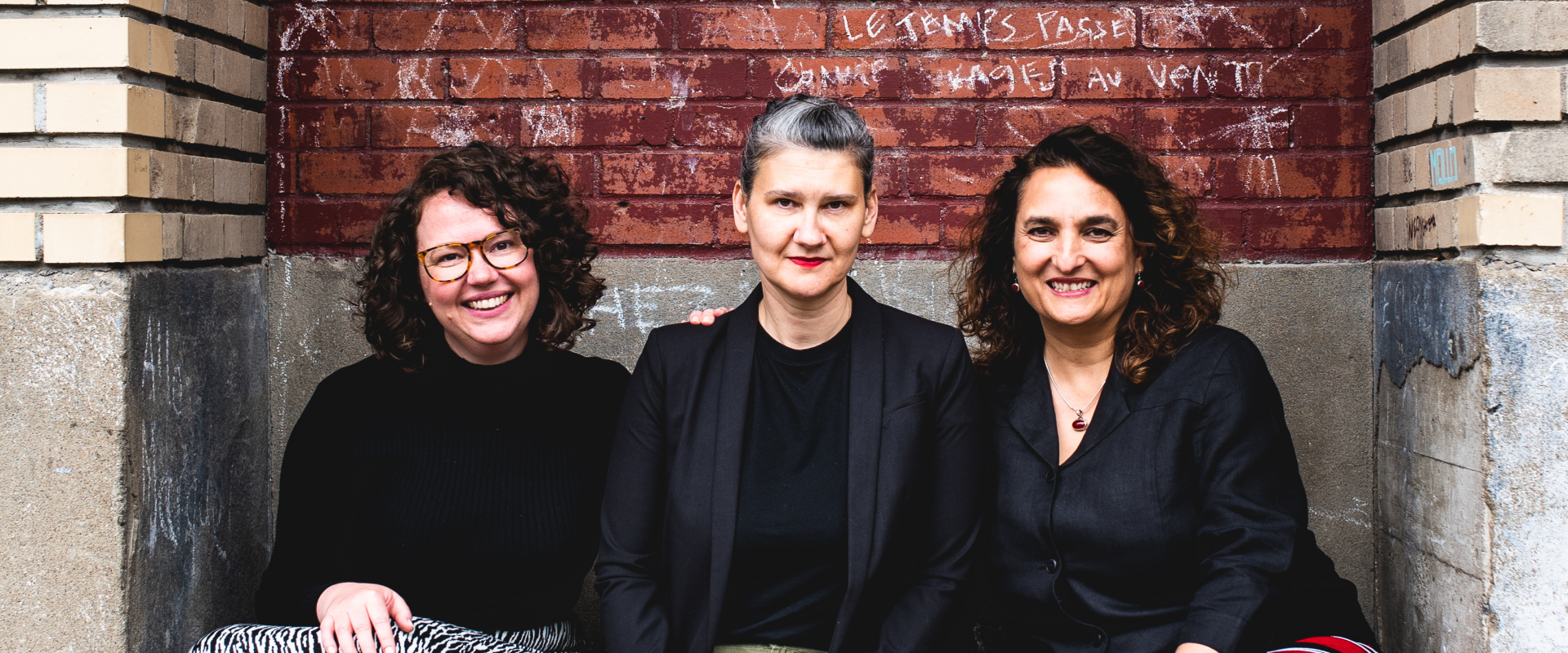 Photo of three women sitting on a stoop